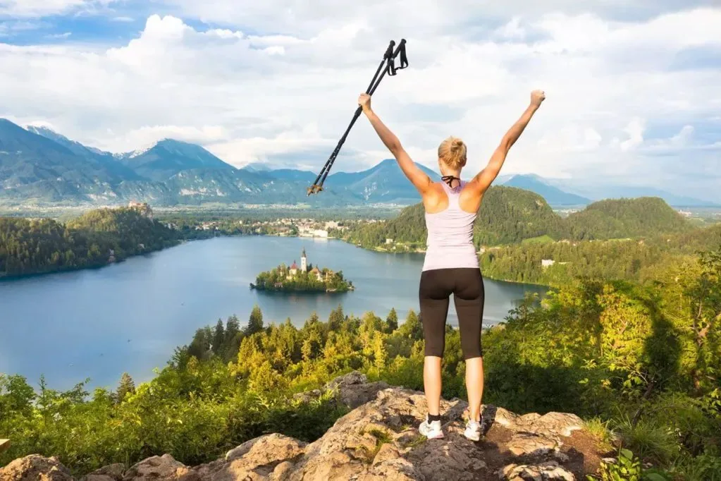 A walking path beside Lake Bled with the island and mountains in view